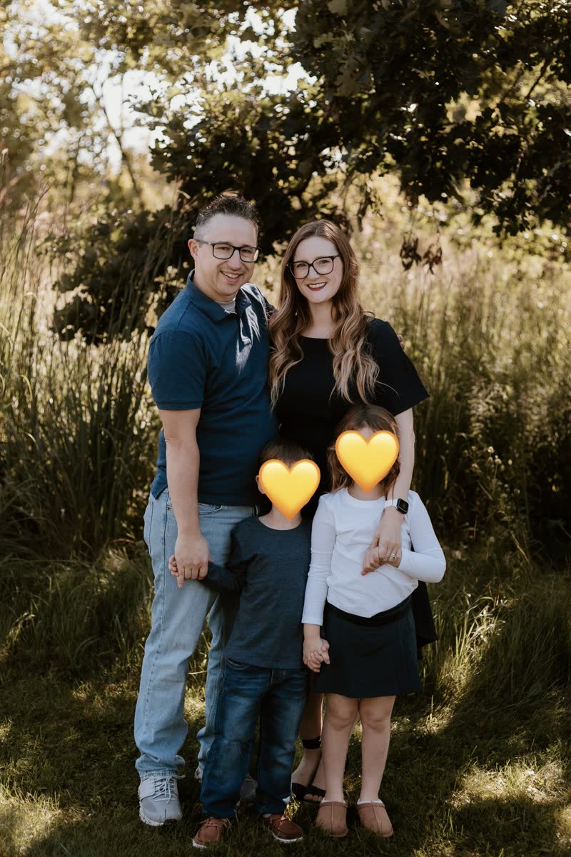 Mercedes Lawson with her family outdoors; children’s faces covered with hearts